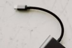 Connecteur USB-C et câble tressé reliés à un adaptateur sur une surface claire