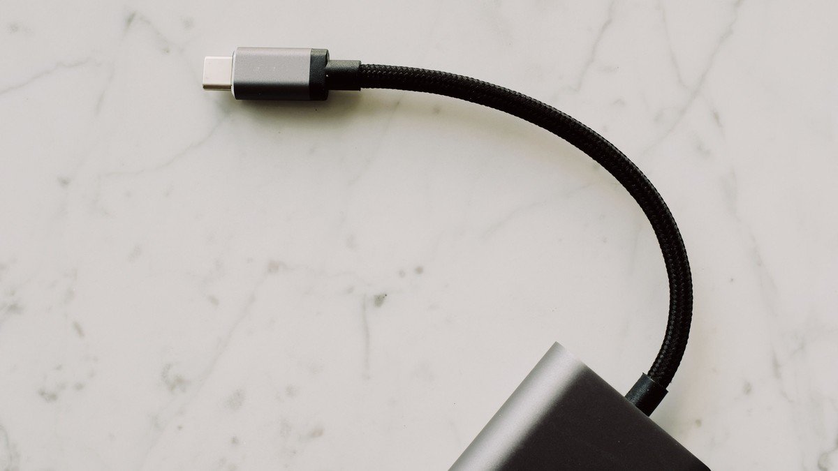 Connecteur USB-C et câble tressé reliés à un adaptateur sur une surface claire