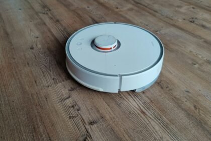 Un ancien robot aspirateur Roborock S50 blanc sur un parquet
