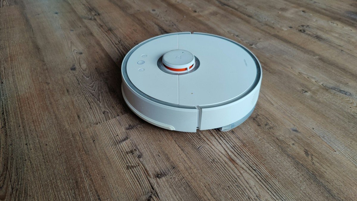 Un ancien robot aspirateur Roborock S50 blanc sur un parquet