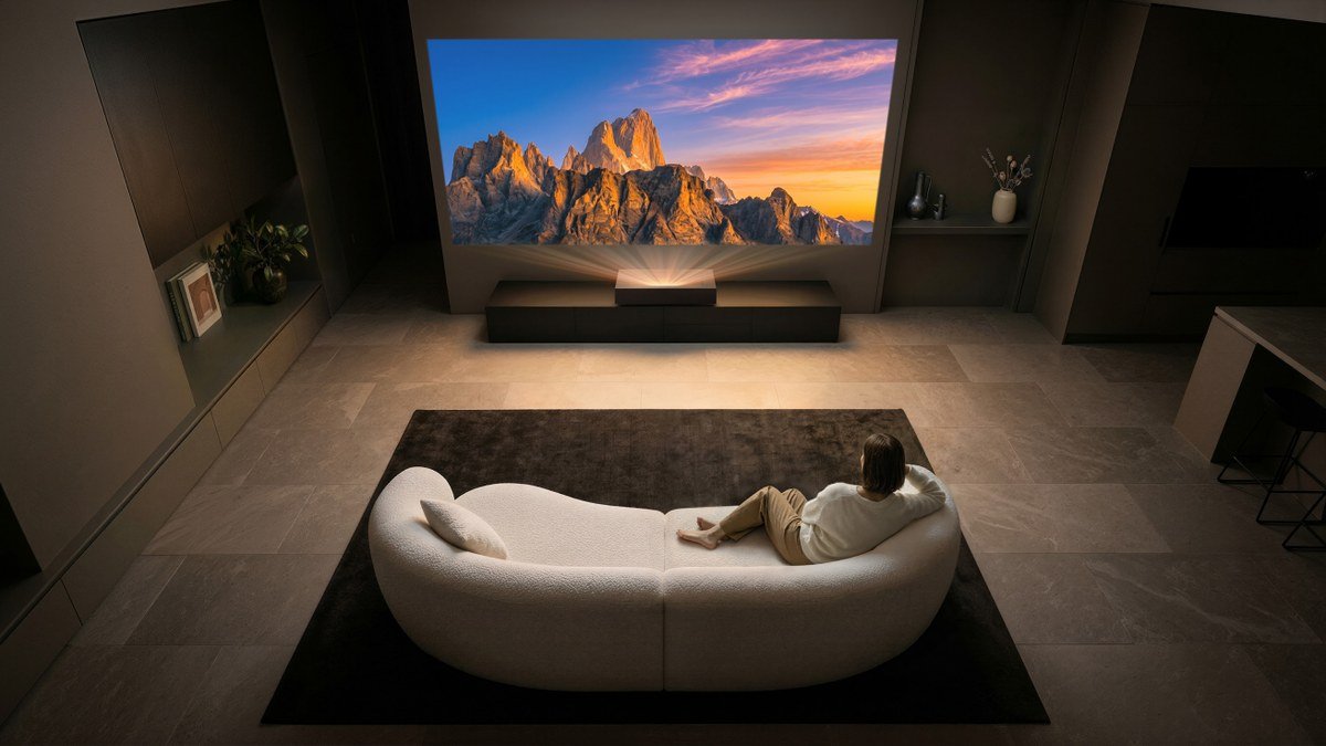 Vidéoprojecteur LG HU925V installé devant un grand écran dans un salon sombre