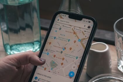 Téléphone affichant Google Maps, tenu au-dessus d’une table de café