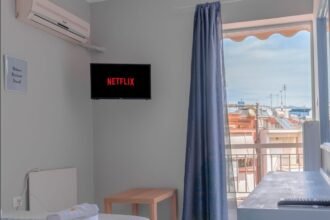 Un téléviseur mural dans une pièce éclairée par une porte-fenêtre