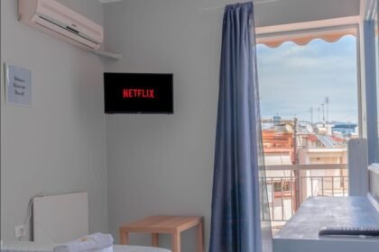 Un téléviseur mural dans une pièce éclairée par une porte-fenêtre