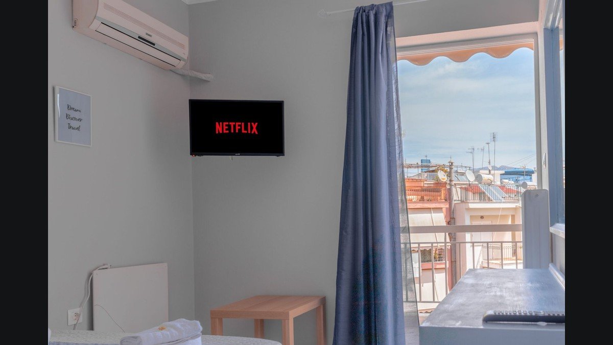 Un téléviseur mural dans une pièce éclairée par une porte-fenêtre