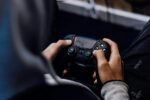 Un joueur tient une manette noire dans ses mains