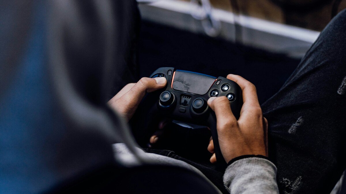 Un joueur tient une manette noire dans ses mains