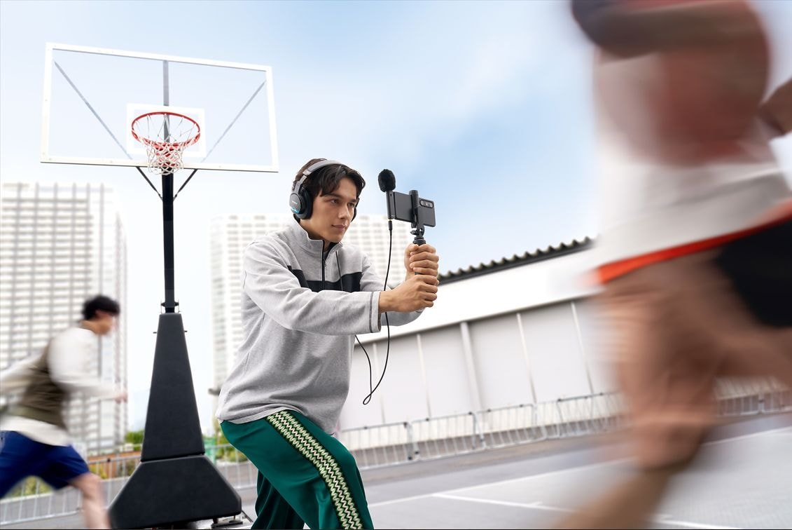 Créateur filmant une partie de basket avec un smartphone équipé du microphone Sony ECM-AX10