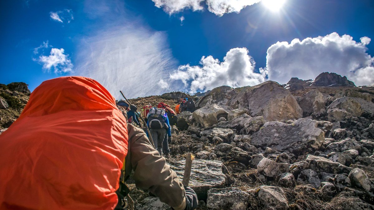 Randonneurs avec des sacs à dos sur un sentier de montagne rocheux