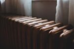 Radiateur en fonte sous une fenêtre éclairée par la lumière du jour
