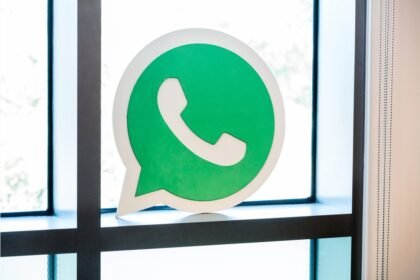 Enseigne verte WhatsApp posée devant une fenêtre dans les locaux de Facebook